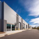 Modern Industrial Park: Warehouse Exterior Design with Metal Siding and Glass Facades under a Sunny Sky