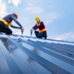 Selective focus roof, construction worker safety wear using electric drill tools install on new roof metal sheet, Roof construction concept.