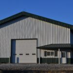 Metal white and green shop building with large garage door