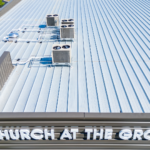 Close-up aerial view of a standing seam metal roof system with rooftop HVAC equipment installed on a commercial building, highlighting roof durability, panel performance, and mechanical integration.