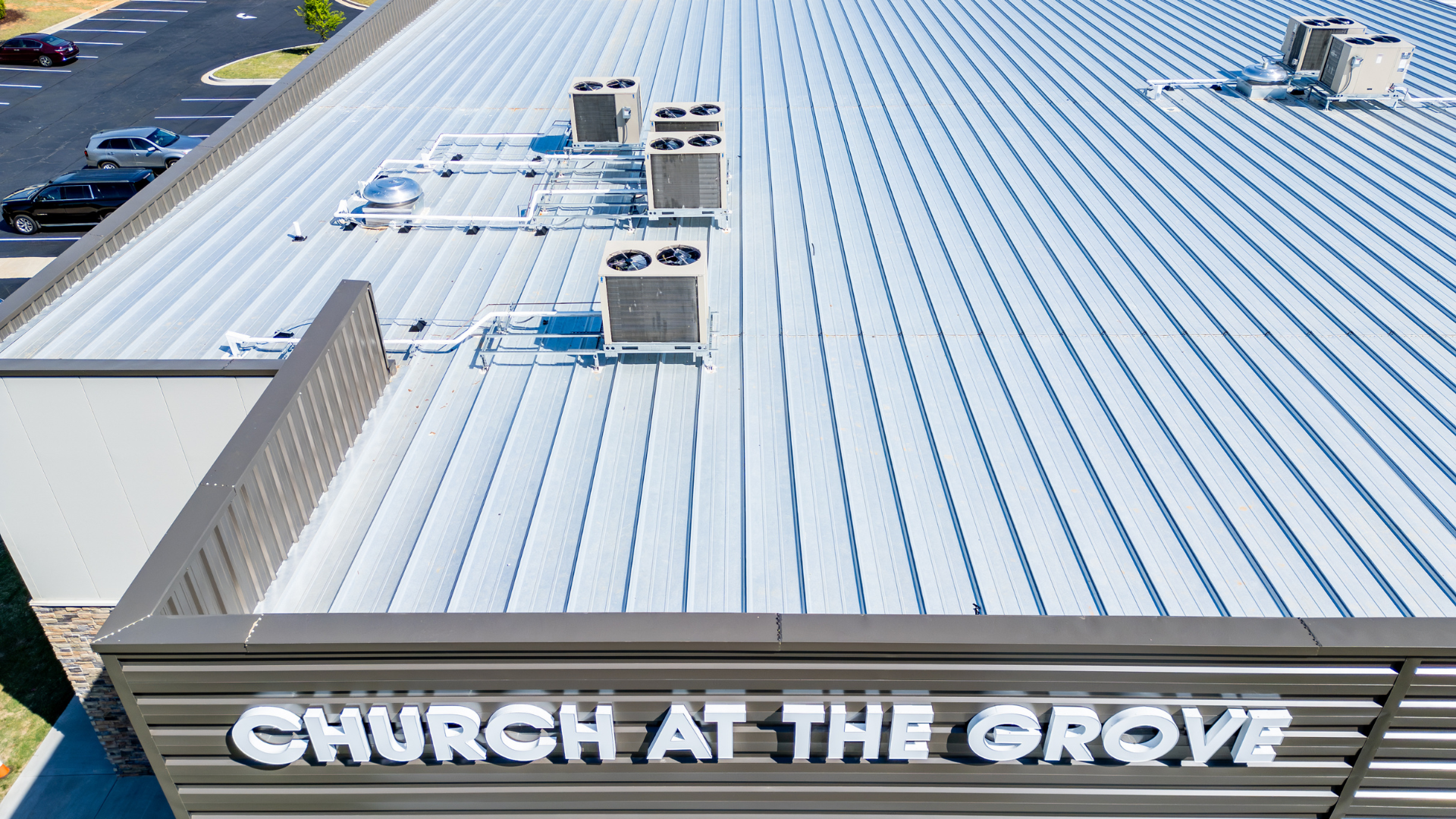 Close-up aerial view of a standing seam metal roof system with rooftop HVAC equipment installed on a commercial building, highlighting roof durability, panel performance, and mechanical integration.