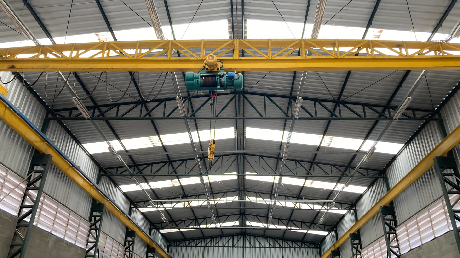 Interior of a small bay industrial building featuring open-span steel framing, overhead crane systems, and flexible warehouse space designed for light industrial and flex space operations.