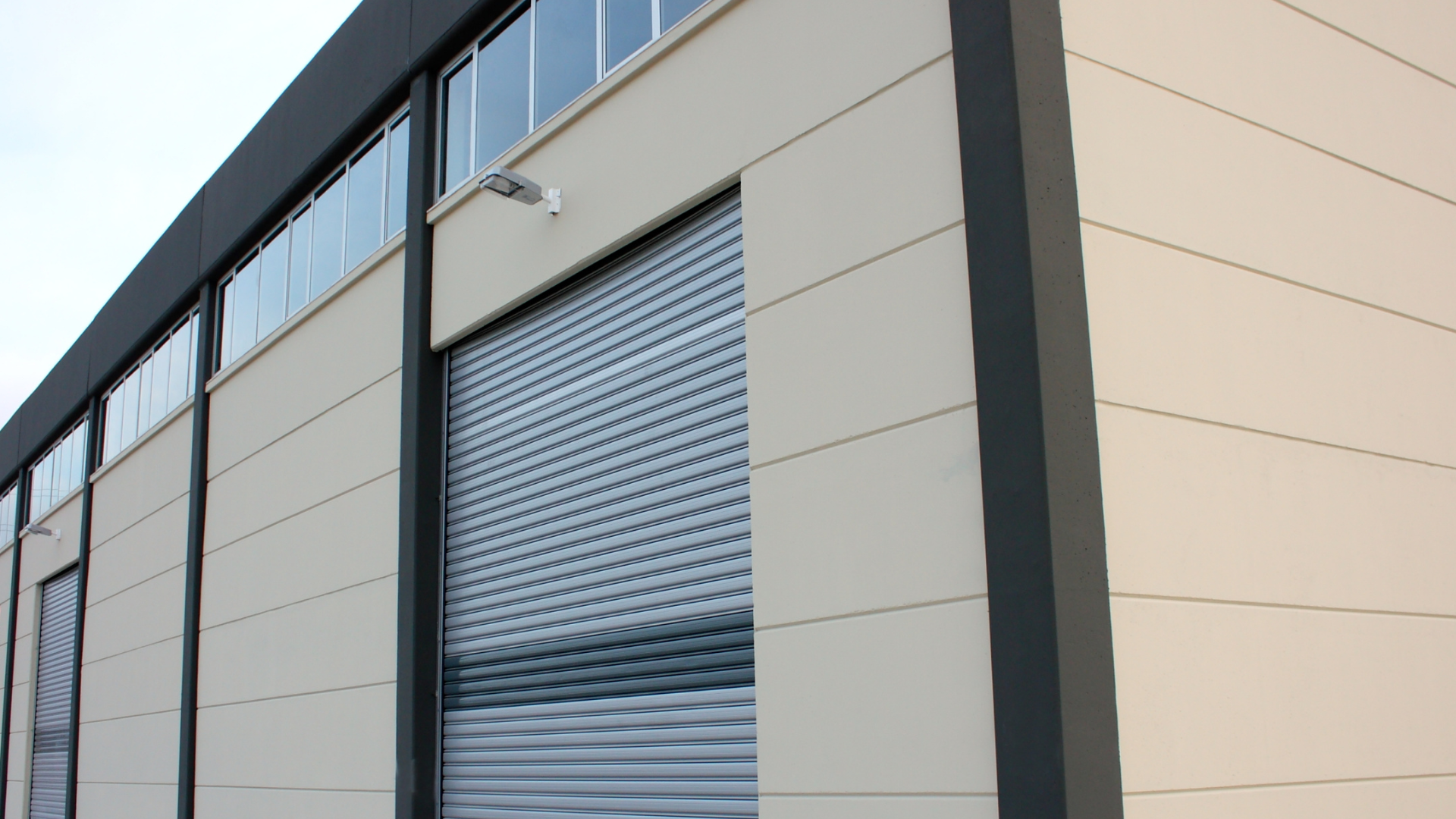 Modern small bay industrial flex space with roll-up doors and contemporary storefront design, supporting warehouse, office, and light industrial tenants.