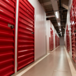 Interior hallway of a modern self-storage facility featuring secure roll-up storage unit doors and wide access aisles.