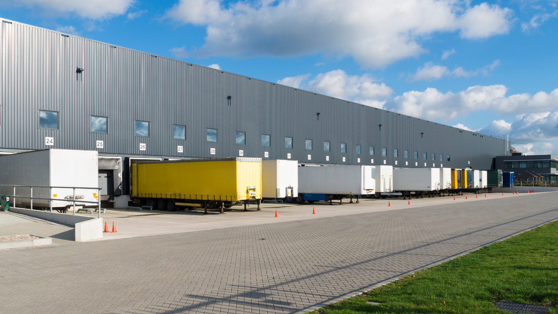 Large distribution center with truck loading docks and steel-framed warehouse construction.