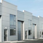 Modern flex industrial building with multiple storefront warehouse units featuring overhead doors, offices, and adaptable commercial space.