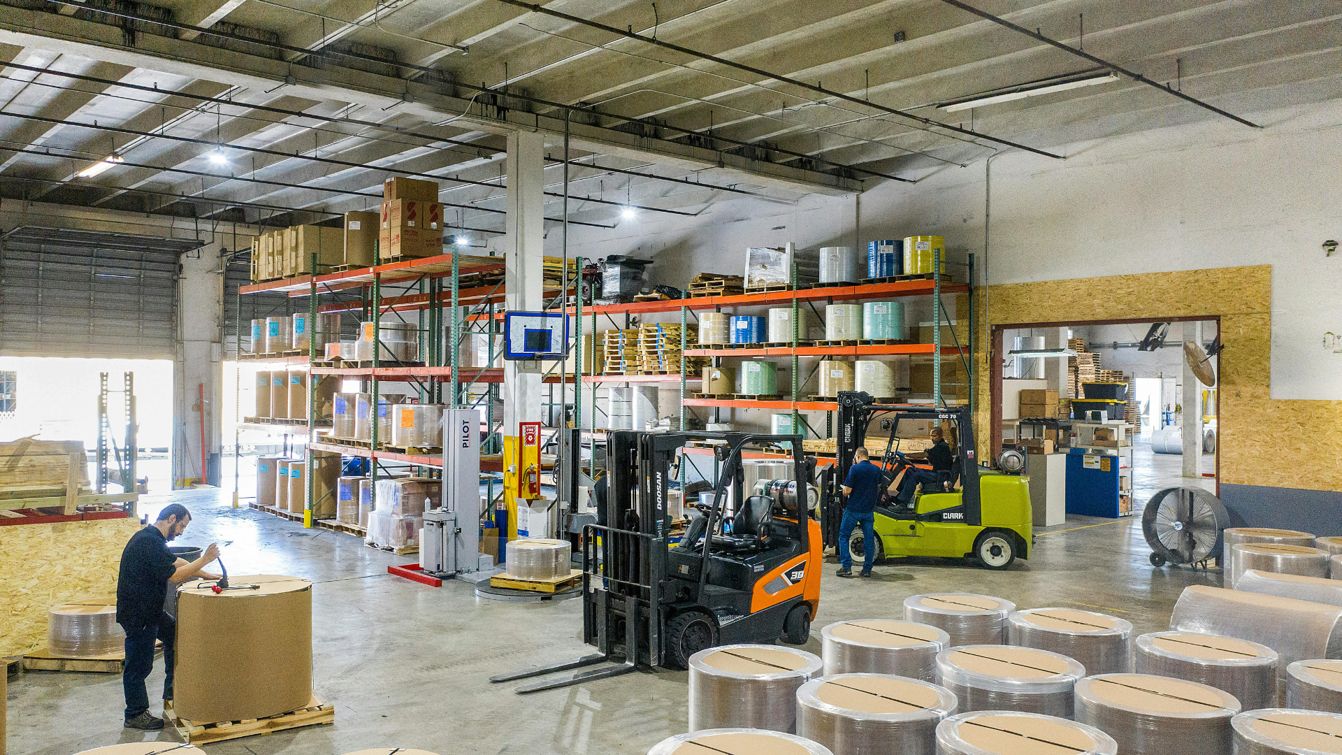 Interior of a flex industrial building with warehouse storage, forklifts, pallet racking, and open workspace for manufacturing and distribution.